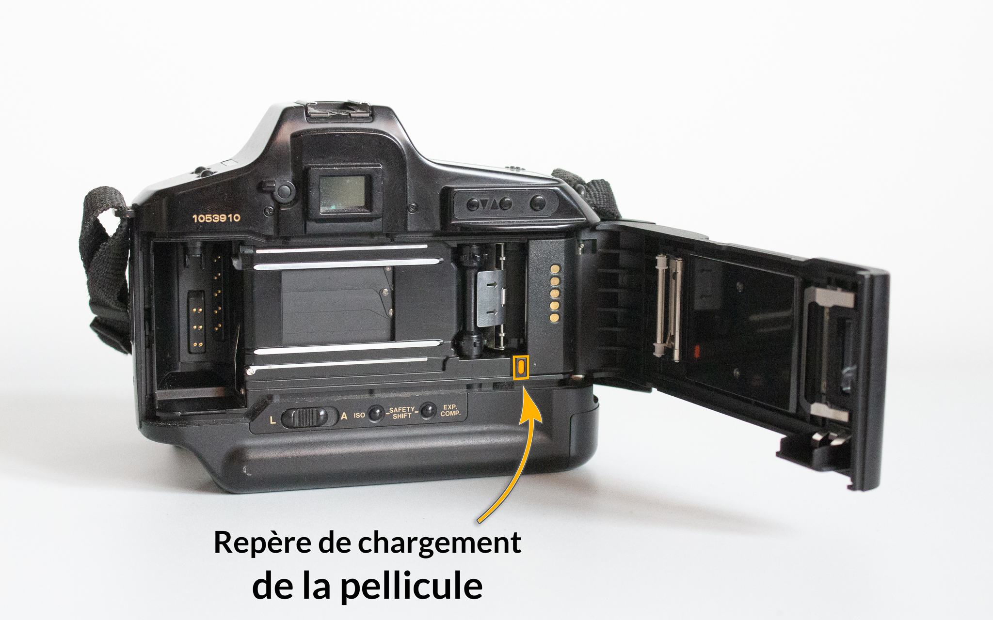 Photographie d'un Canon T90 avec un élément nommé et situé : le repère de chargement de la pellicule, un petit carré jaune situé à droite de l'appareil